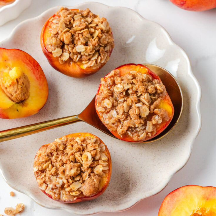 Three baked peaches topped with buttery oat crumble.