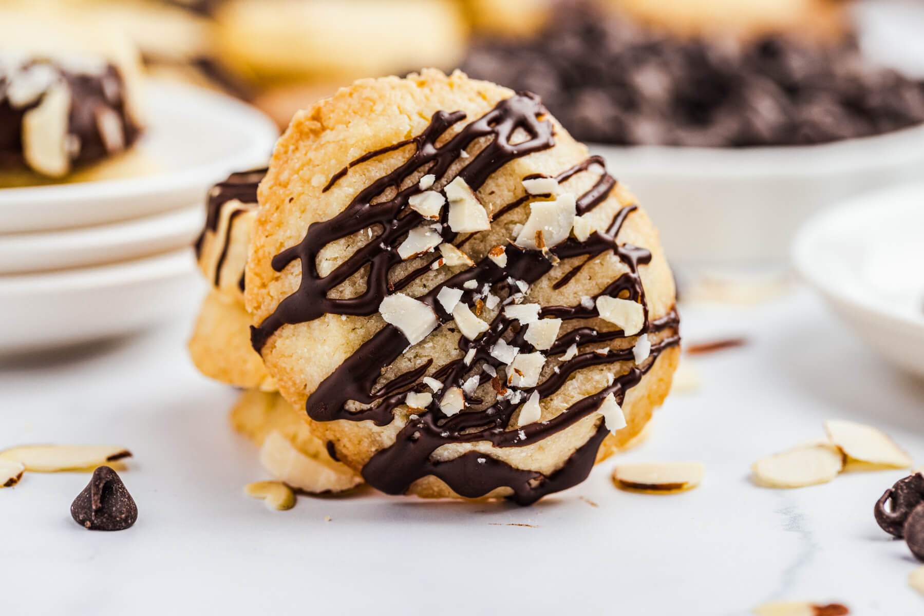 One round shortbread cookie drizzled with chocolate and decorated with chopped almonds.