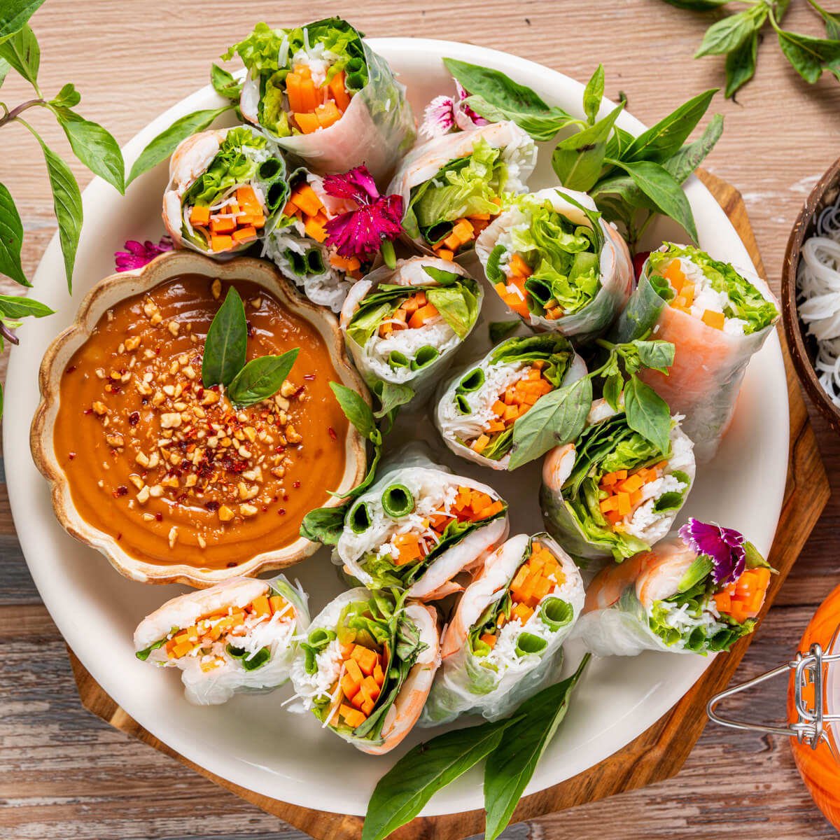 A platter of vibrant Vietnamese Shrimp Salad rolls sliced in half showing bright vegetables and noodles.