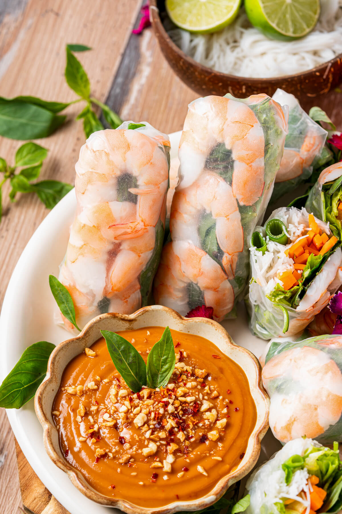 A platter of vibrant Vietnamese Shrimp Salad rolls beside a bowl of peanut sauce.