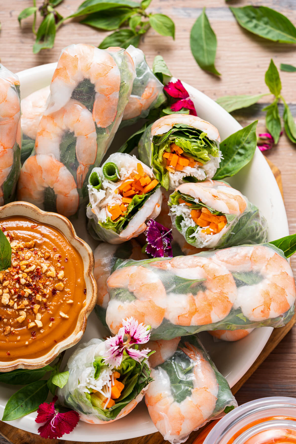 A platter of vibrant Vietnamese Shrimp Salad rolls sliced in half showing bright vegetables and noodles.