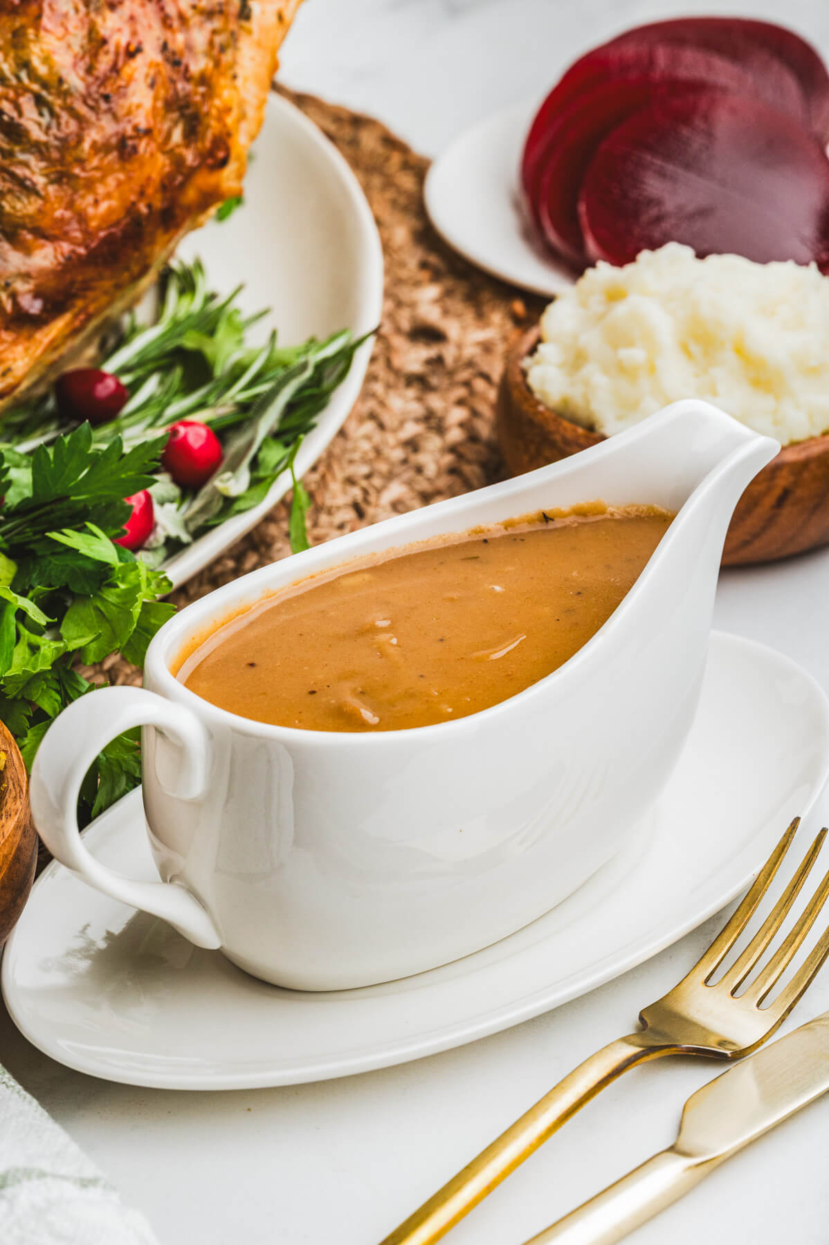 A white gravy boat filled with rich brown gravy.