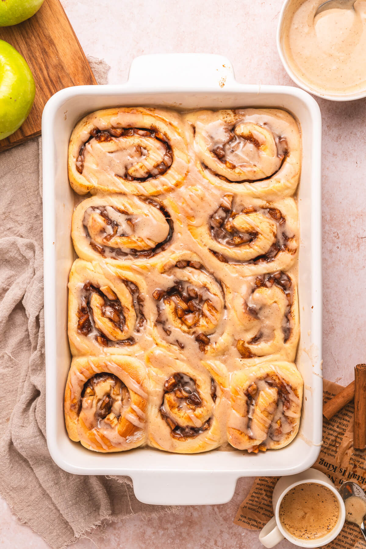 A white baking dish containing freshly baked apple pie cinnamon rolls.