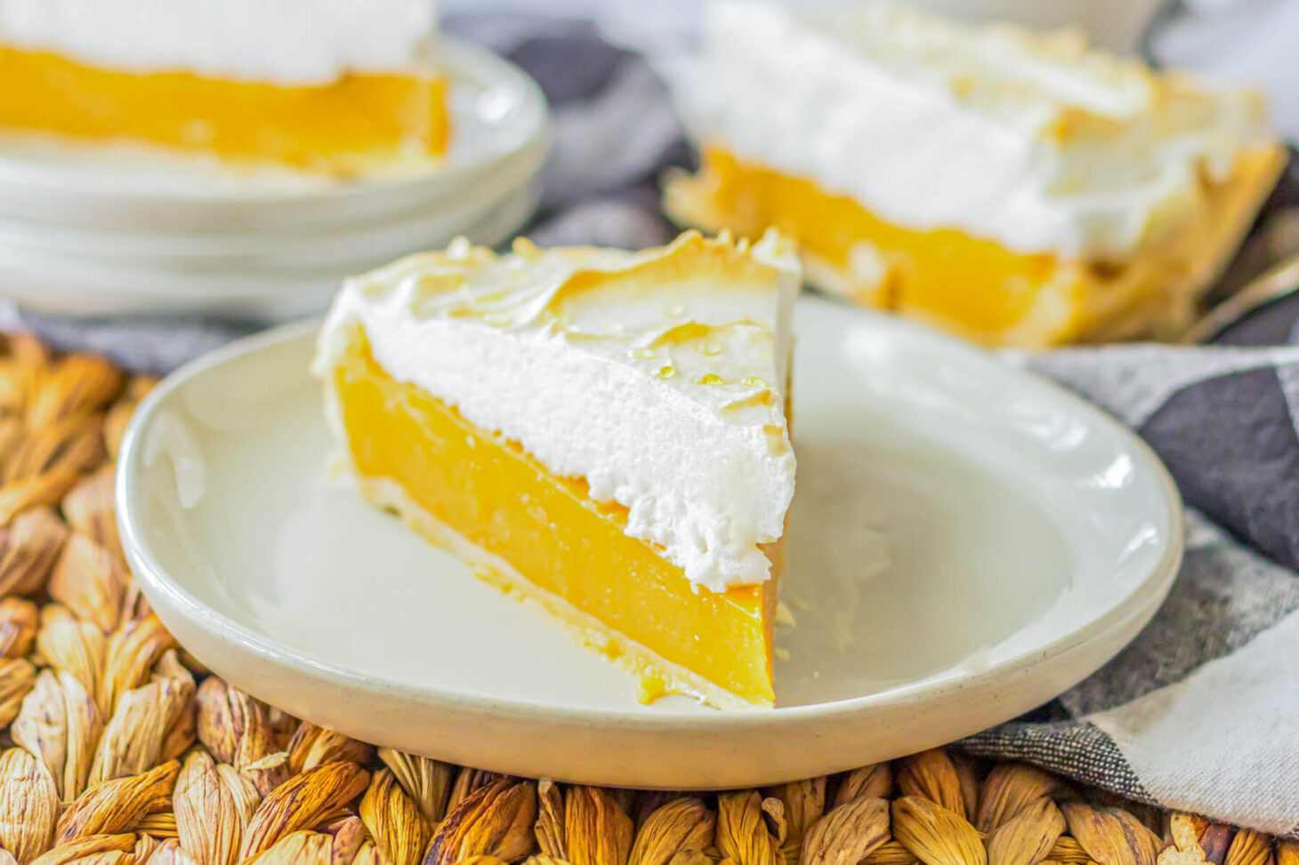 A slice of Butterscotch pie with buttery sweet filling topped with a cloud of toasted meringue on a white plate.