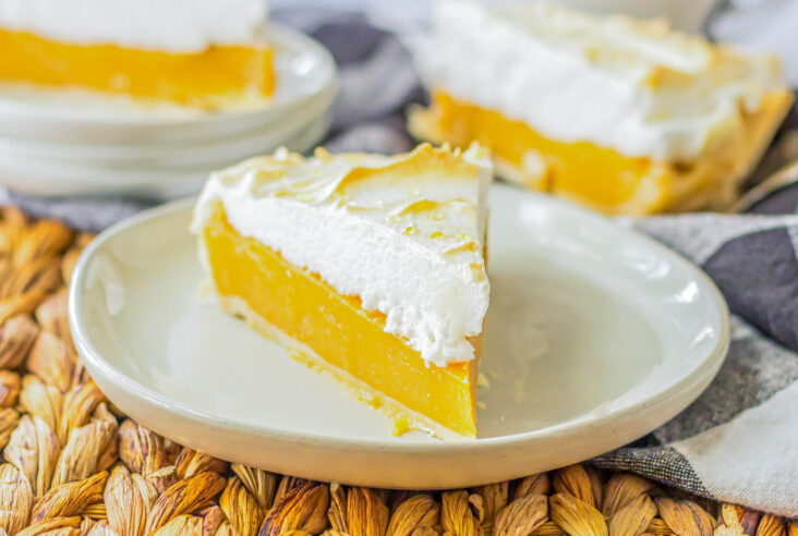 A slice of Butterscotch pie with buttery sweet filling topped with a cloud of toasted meringue on a white plate.