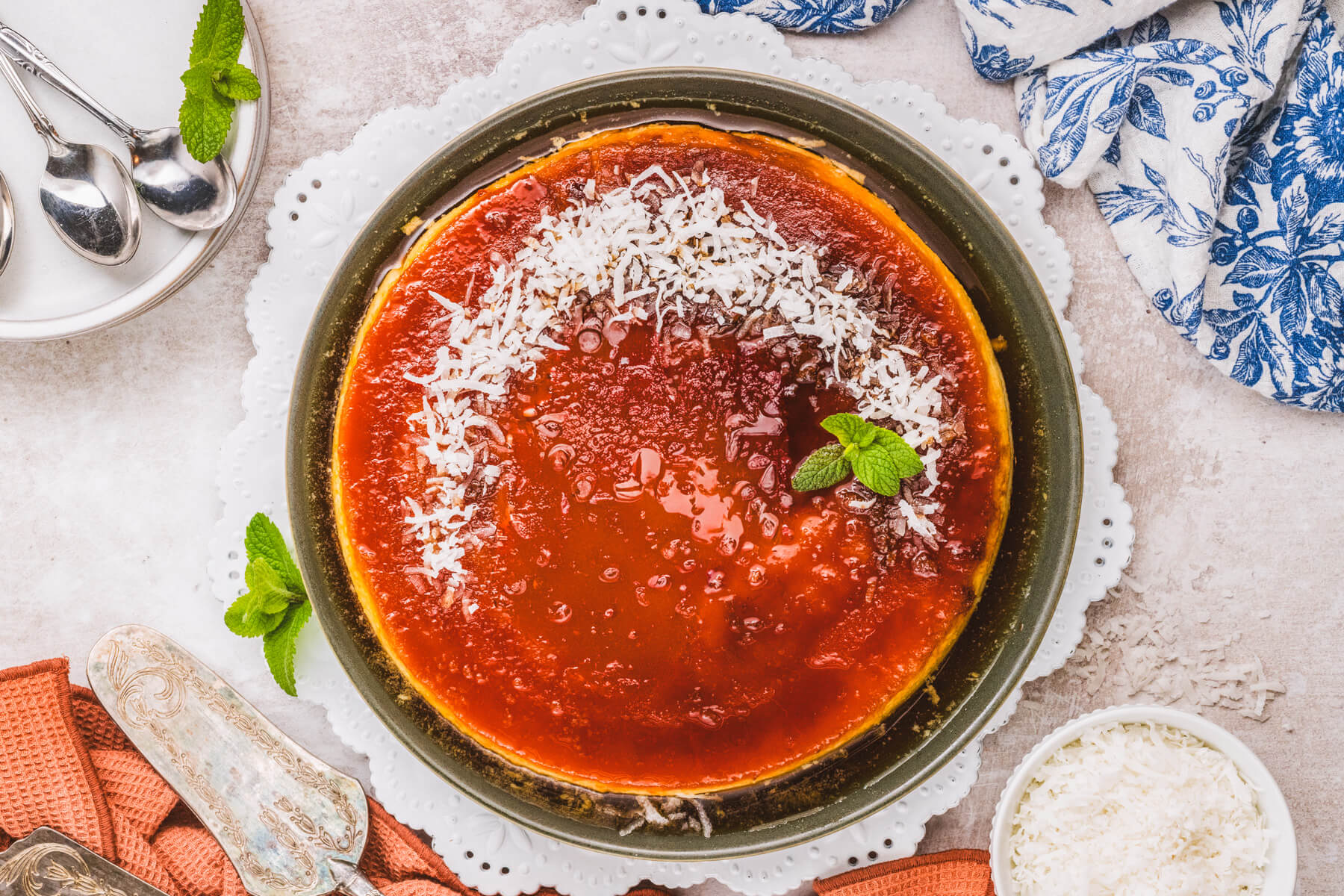 A whole coconut flan topped with a golden brown caramel and coconut flakes.