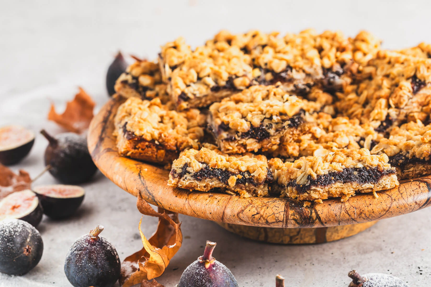 A wooden platter of golden baked crumbly Fig Bars.