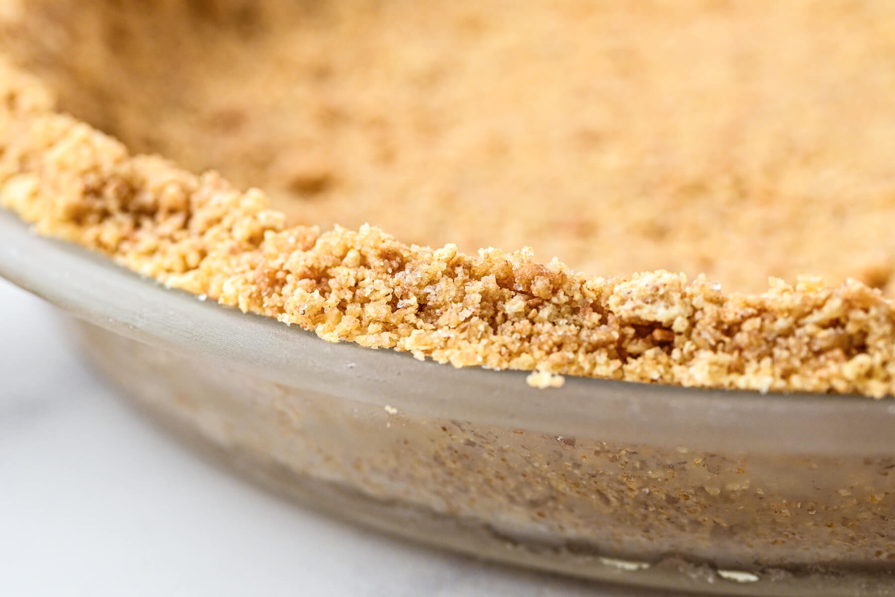 An unfilled 9 inch graham cracker pie crust.