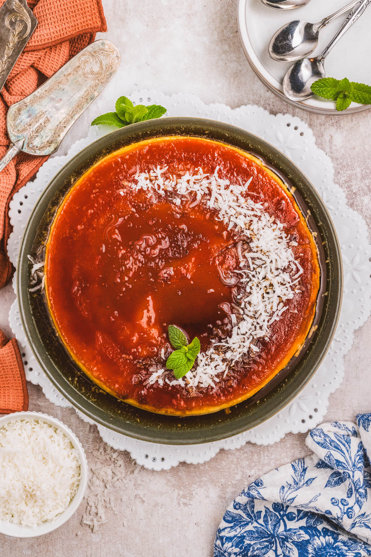 A whole coconut flan topped with a golden brown caramel and coconut flakes.