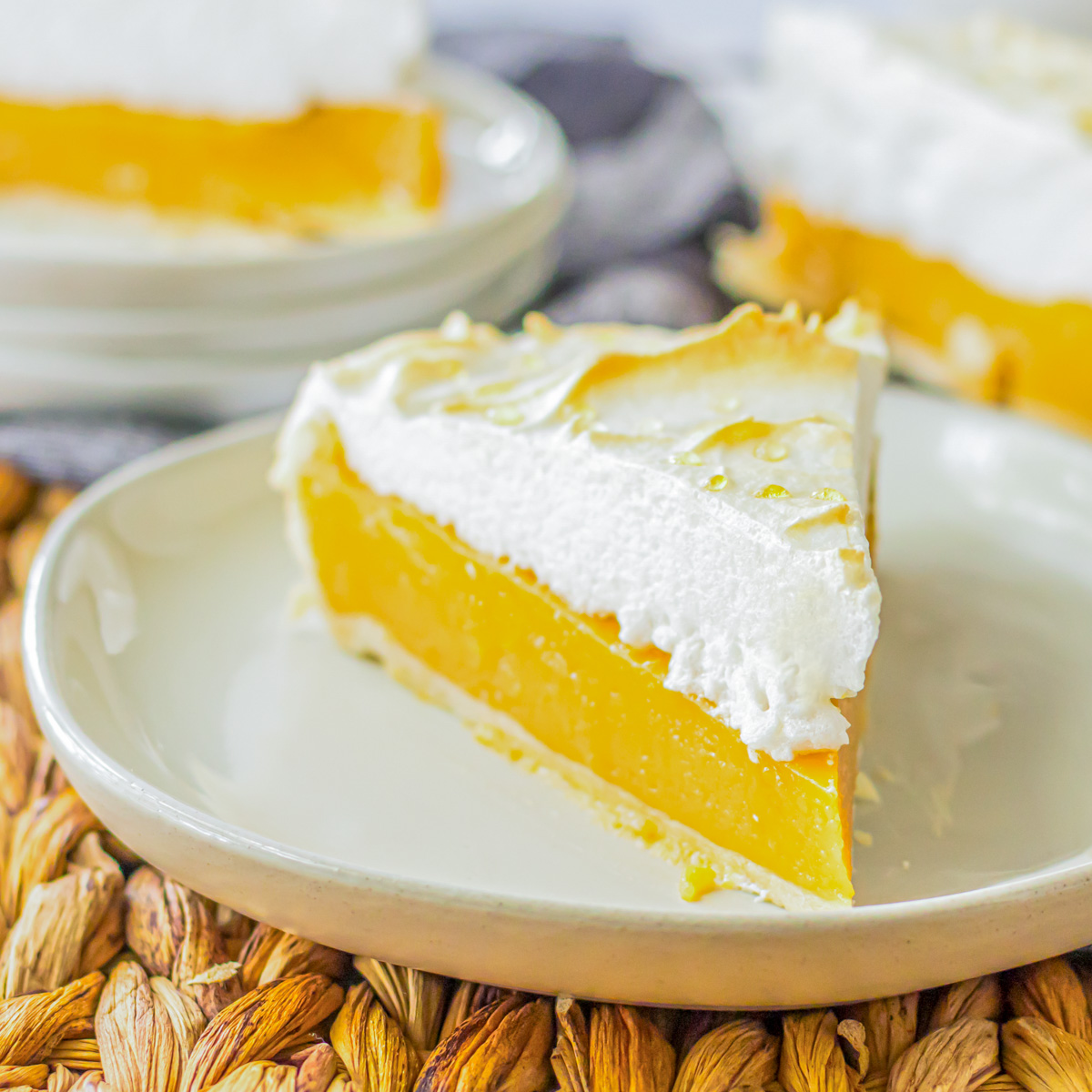 A slice of Butterscotch pie with buttery sweet filling topped with a cloud of toasted meringue on a white plate.