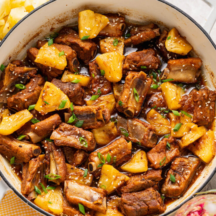 These tender, fall-off-the-bone Sticky Pork Ribs with Pineapple are coated in a sweet-savoury glaze that’s full of rich, umami flavour. A touch of pineapple adds brightness and natural sweetness, balancing the richness of the braised ribs. This easy, flavour-packed dish is perfect served over rice for a comforting and delicious meal the whole family will love.