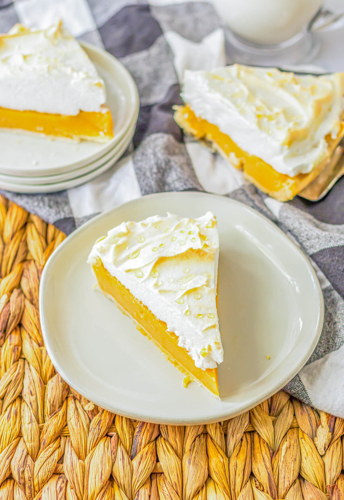 Three slices of Butterscotch pie with buttery sweet filling topped with a cloud of toasted meringue on a white plates.