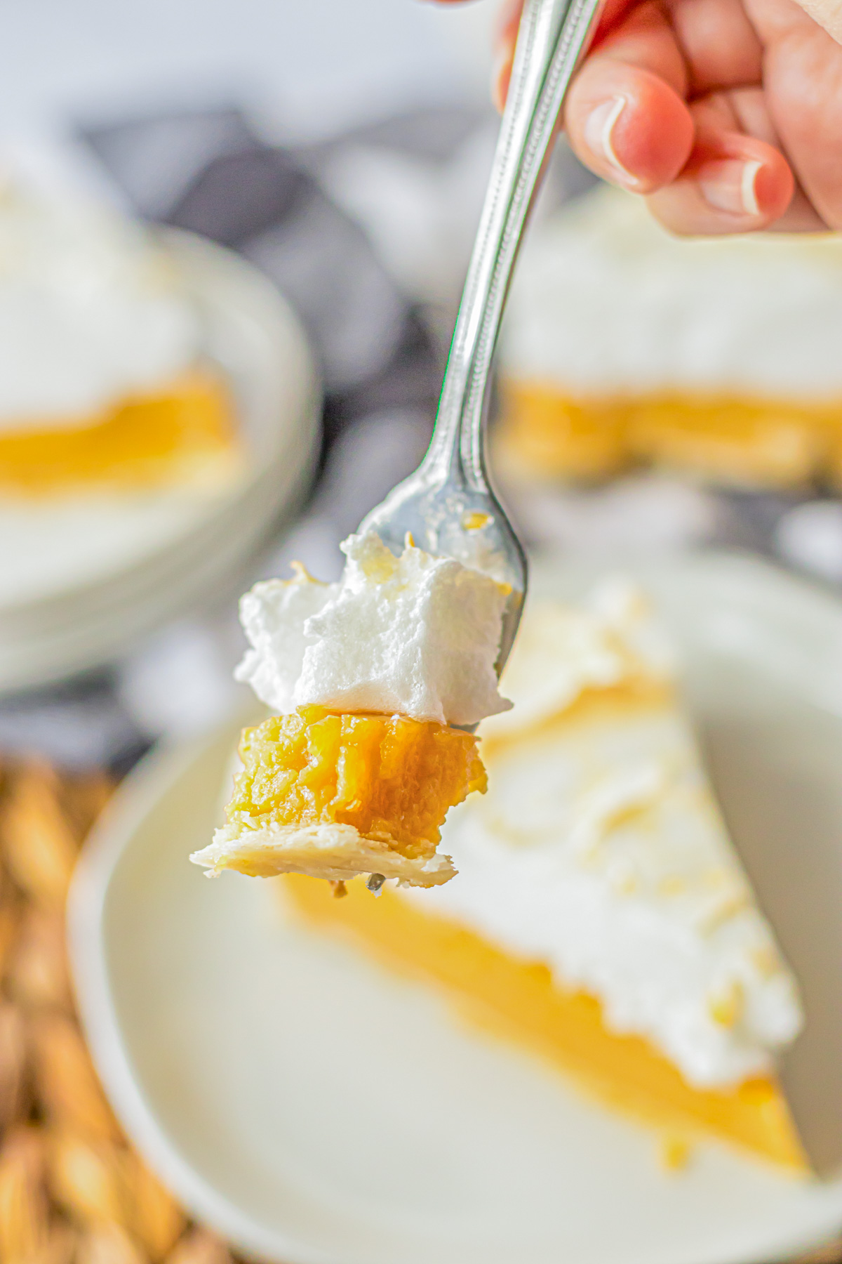 A fork holds a bite of Butterscotch pie showing the butterscotch caramel and meringue layers.