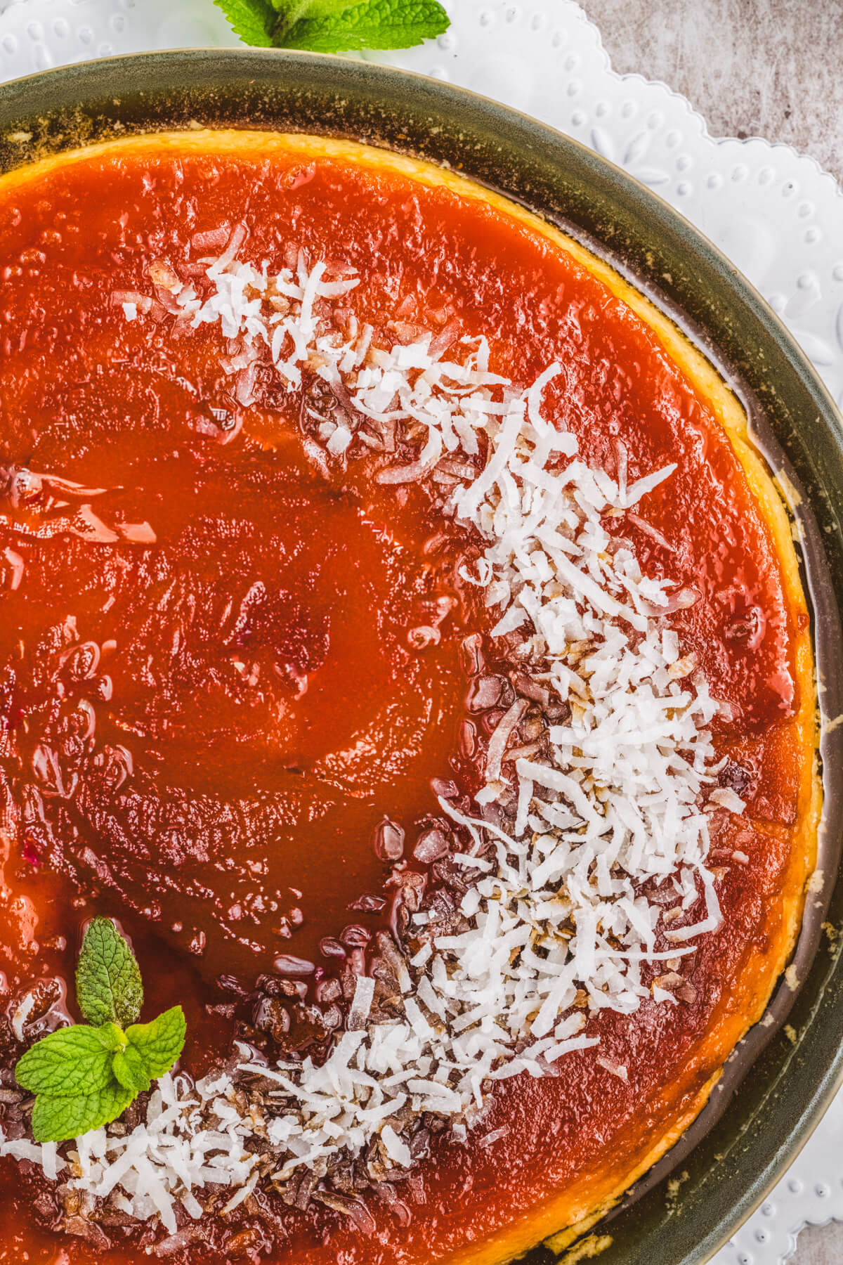 A whole coconut flan topped with a golden brown caramel and coconut flakes.