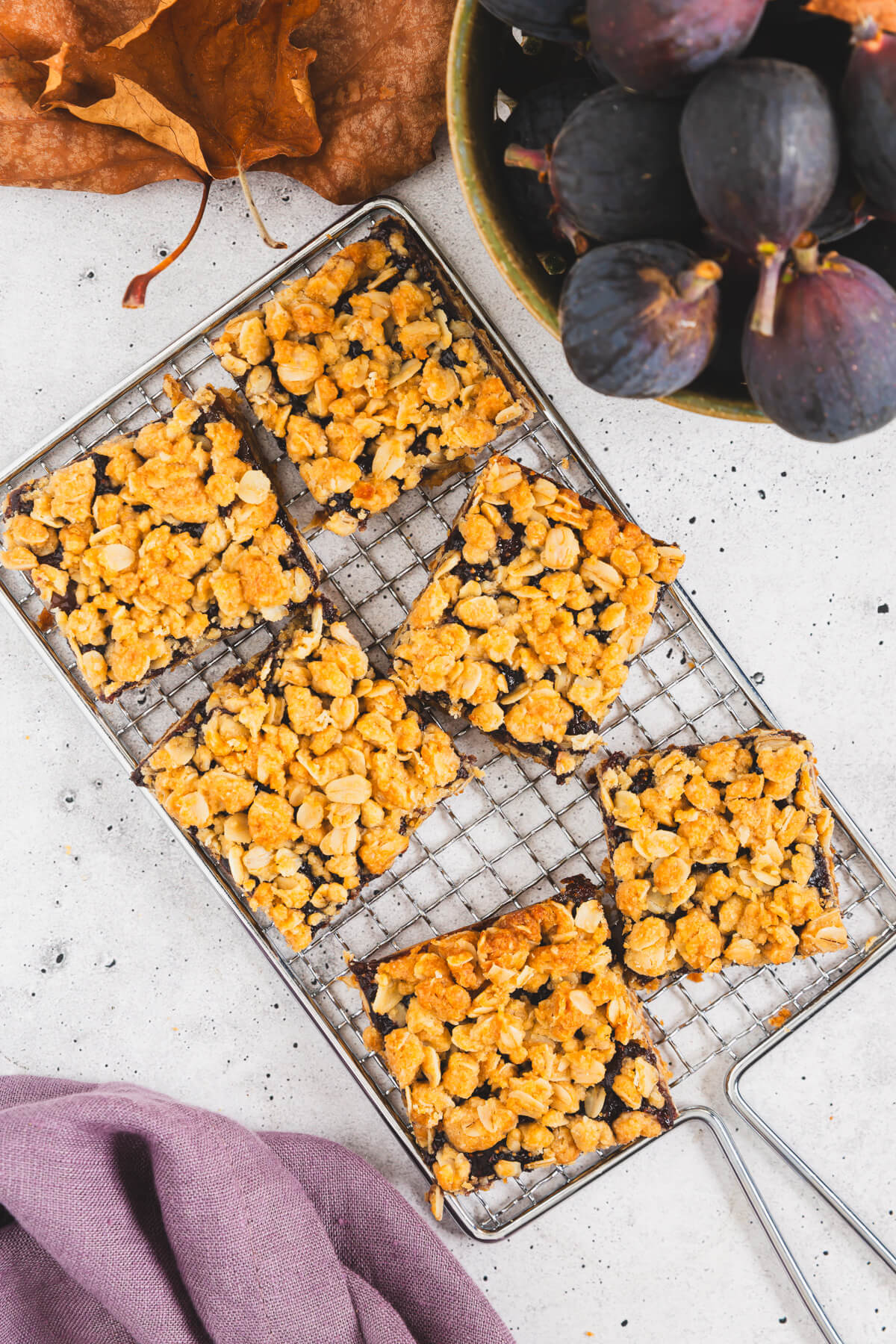 Six golden baked crumby Fig Bars cooling on a wire baking rack.