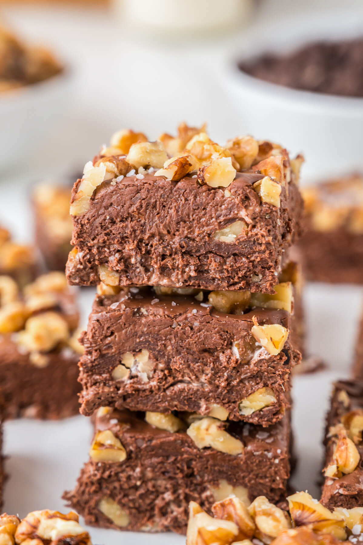 A stack of three squares of chocolate walnut fudge.