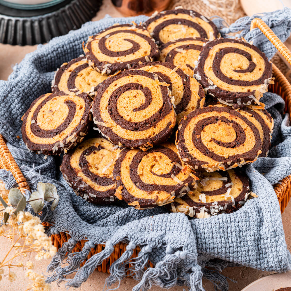 A plate of Chocolate and Vanilla Pinwheel Cookies on a baking counter.