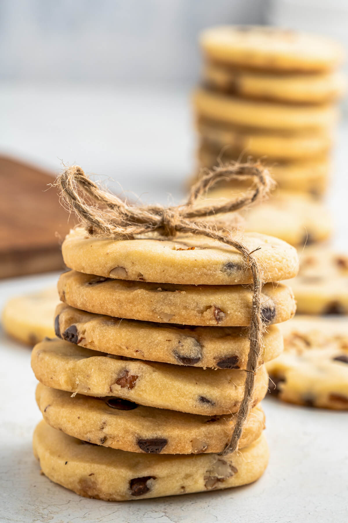 A stack of golden baked shortbread cookies studded with chocolate chips and pecans.