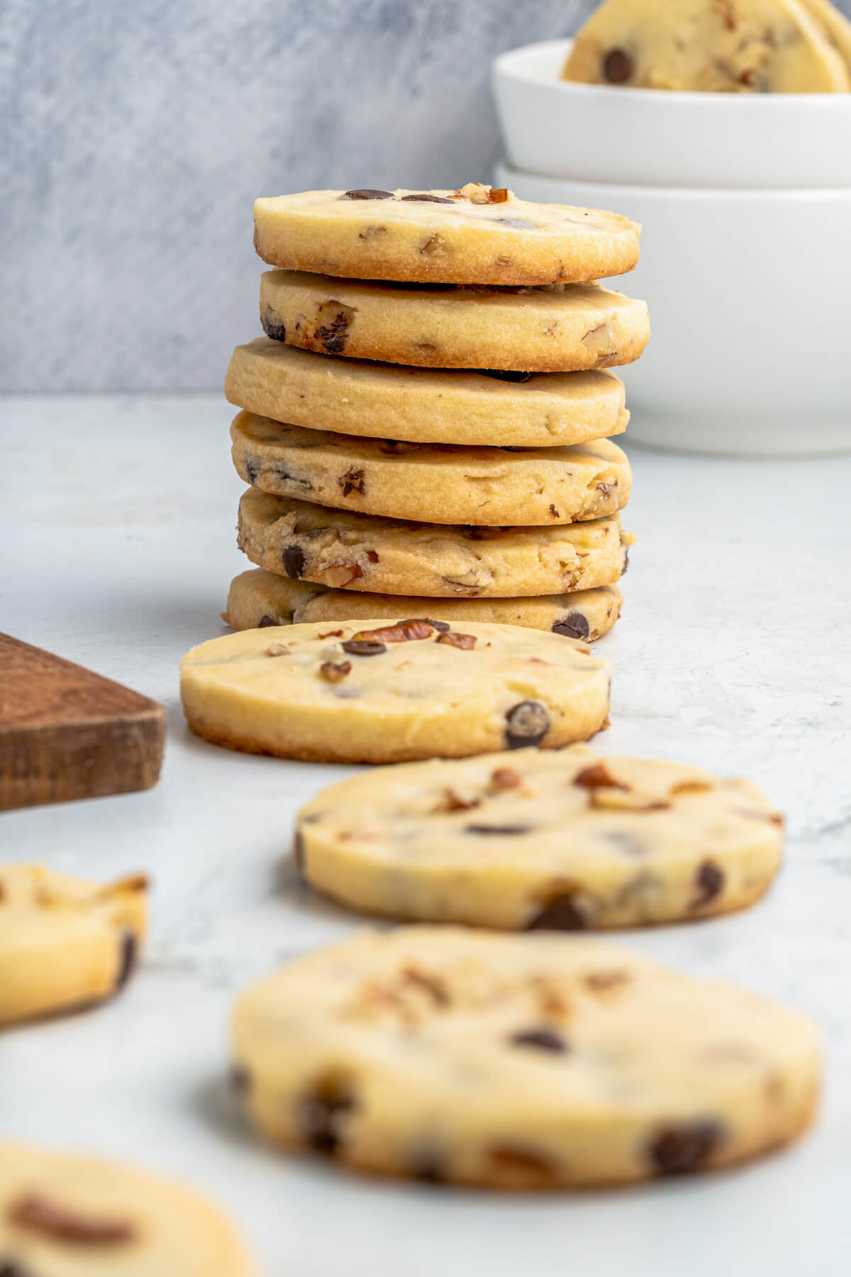 Stacks of golden baked shortbread cookies studded with chocolate chips and pecans.