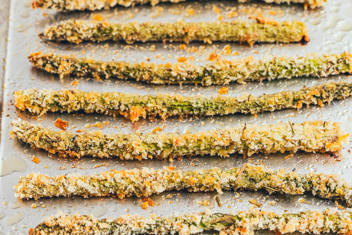 Golden Baked Asparagus fries on an aluminum foil lined baking sheet.