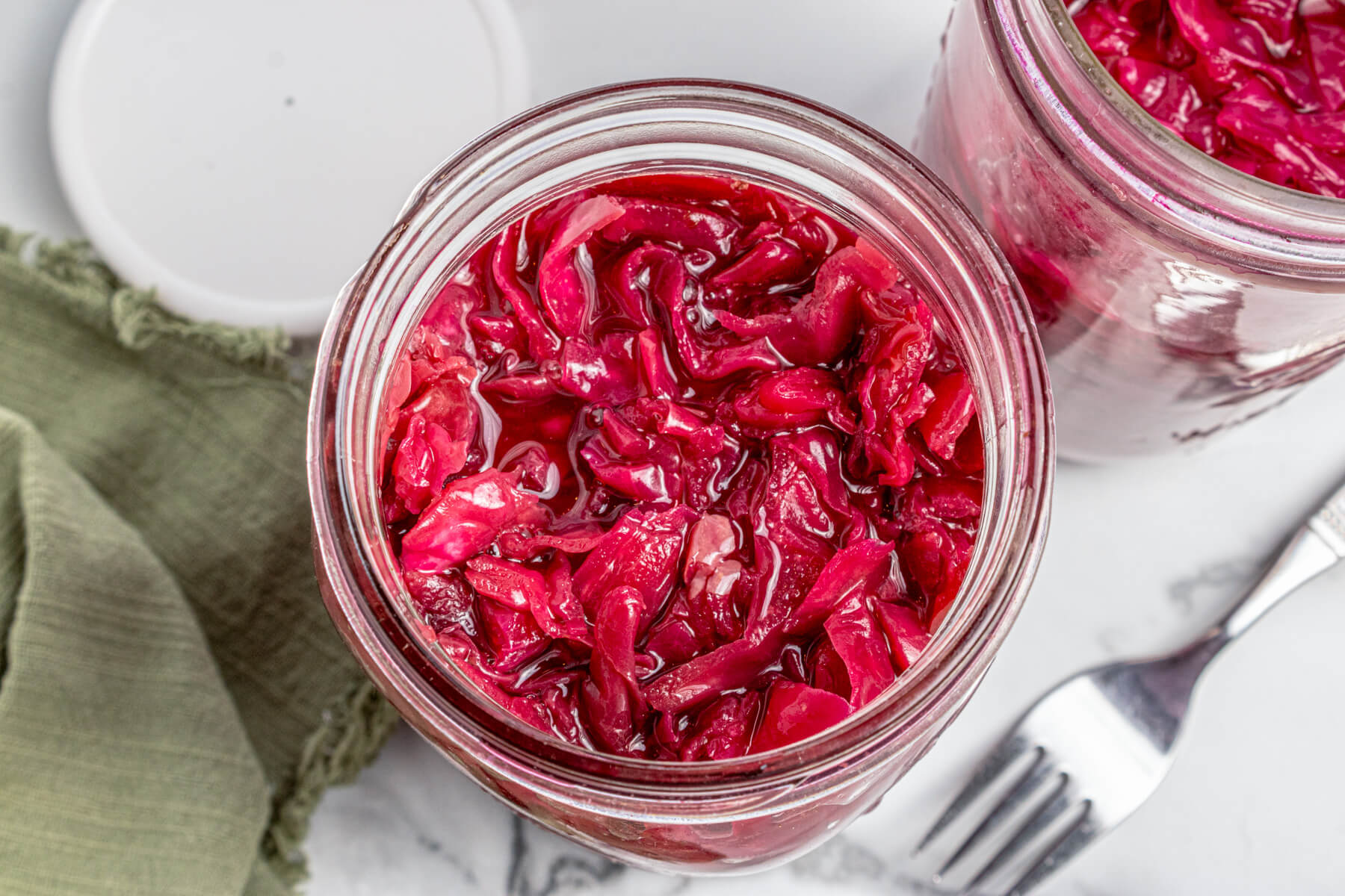 A glass jar filled with fermenting red cabbage.
