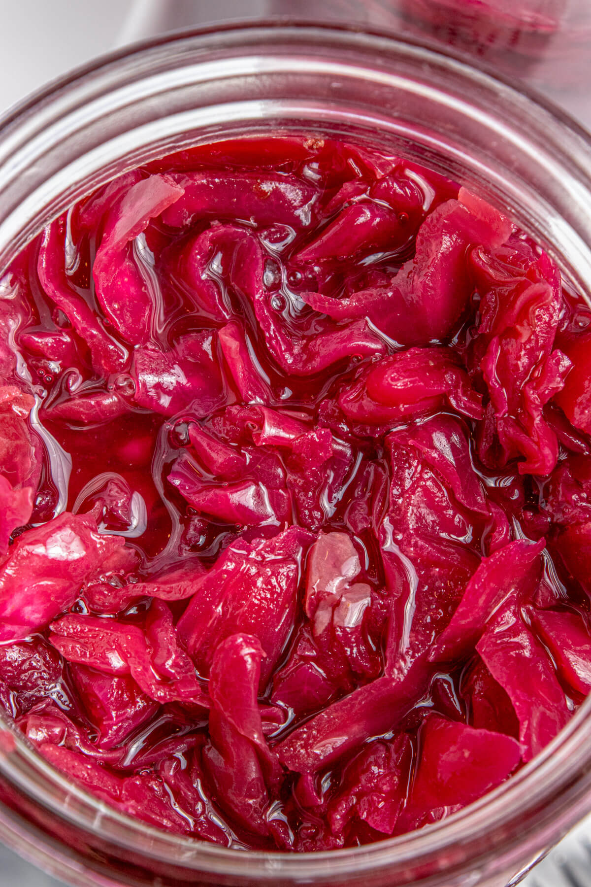 A glass jar filled with fermenting red cabbage.