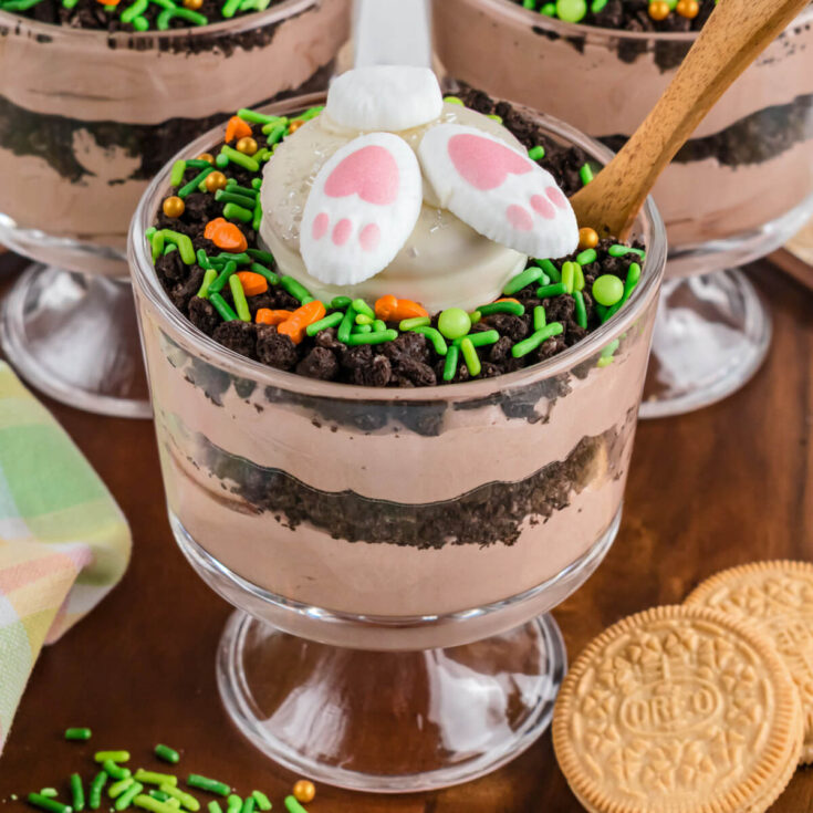 A trio of Easter trifles featuring layers of cookie crumb dirt and chocolate whipped cream topped with a bunny butt cookie.
