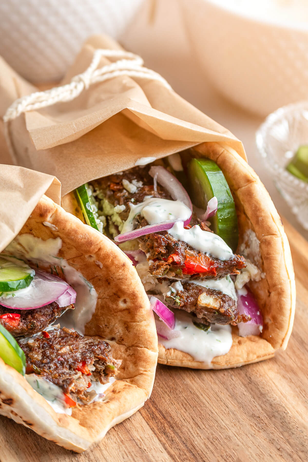 Two pita wraps filled with sheet pan kebabs, vegetables, and yogurt tahini sauce.