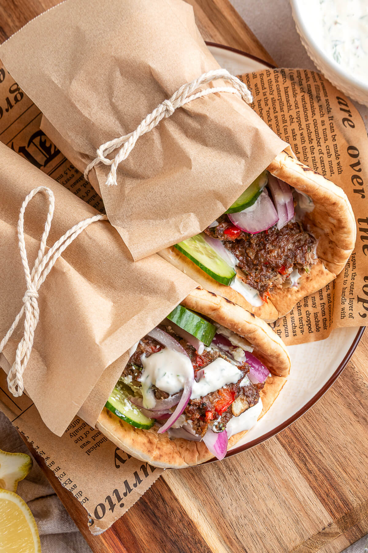 Two pita wraps filled with sheet pan kebabs, vegetables, and yogurt tahini sauce.