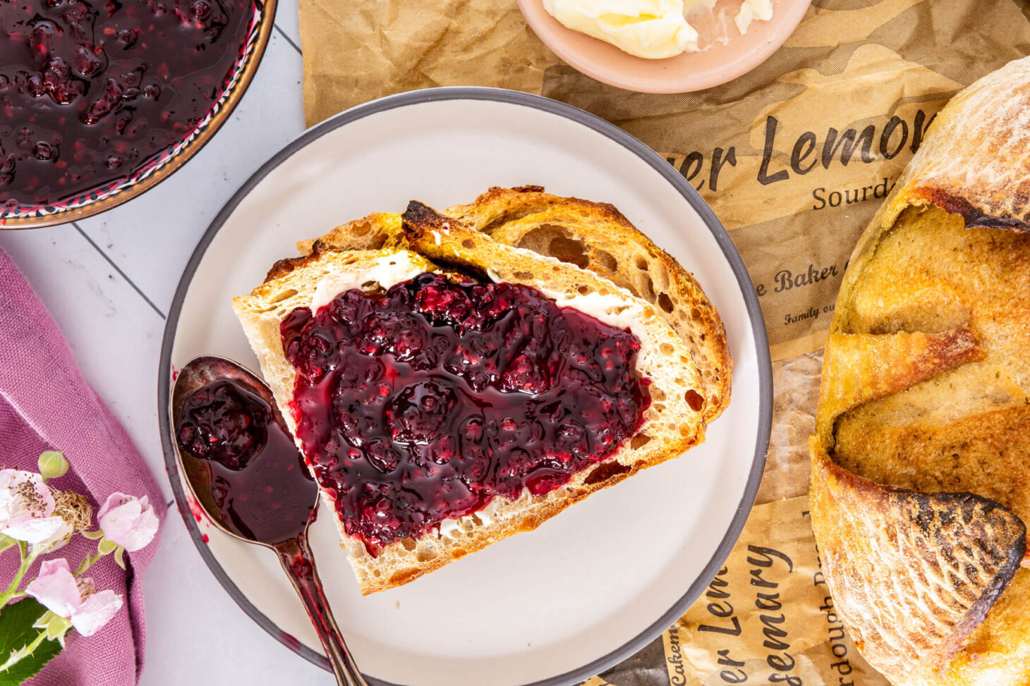 Slices of sourdough bread topped with glistening homemade blackberry jam.