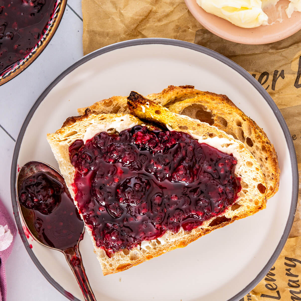 Slices of sourdough bread topped with glistening homemade blackberry jam.