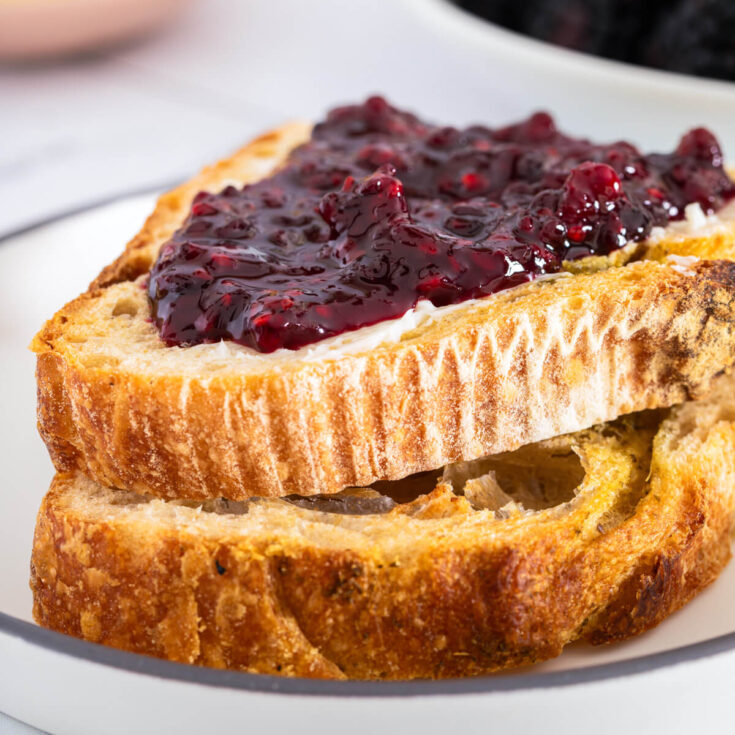 Slices of sourdough bread topped with glistening homemade blackberry jam.