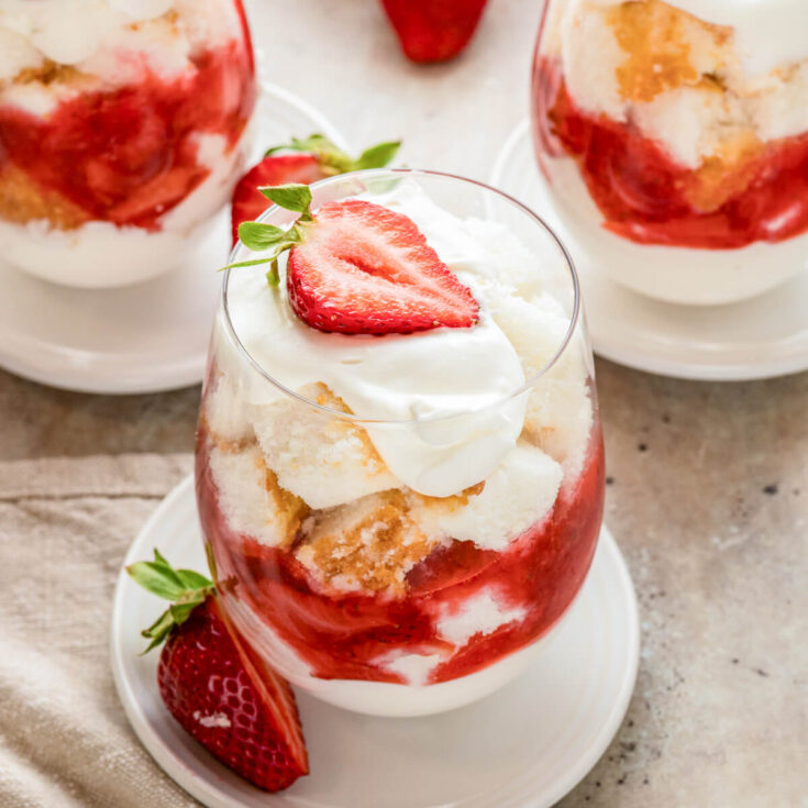 A mini strawberry trifle in a stemless wine glass.