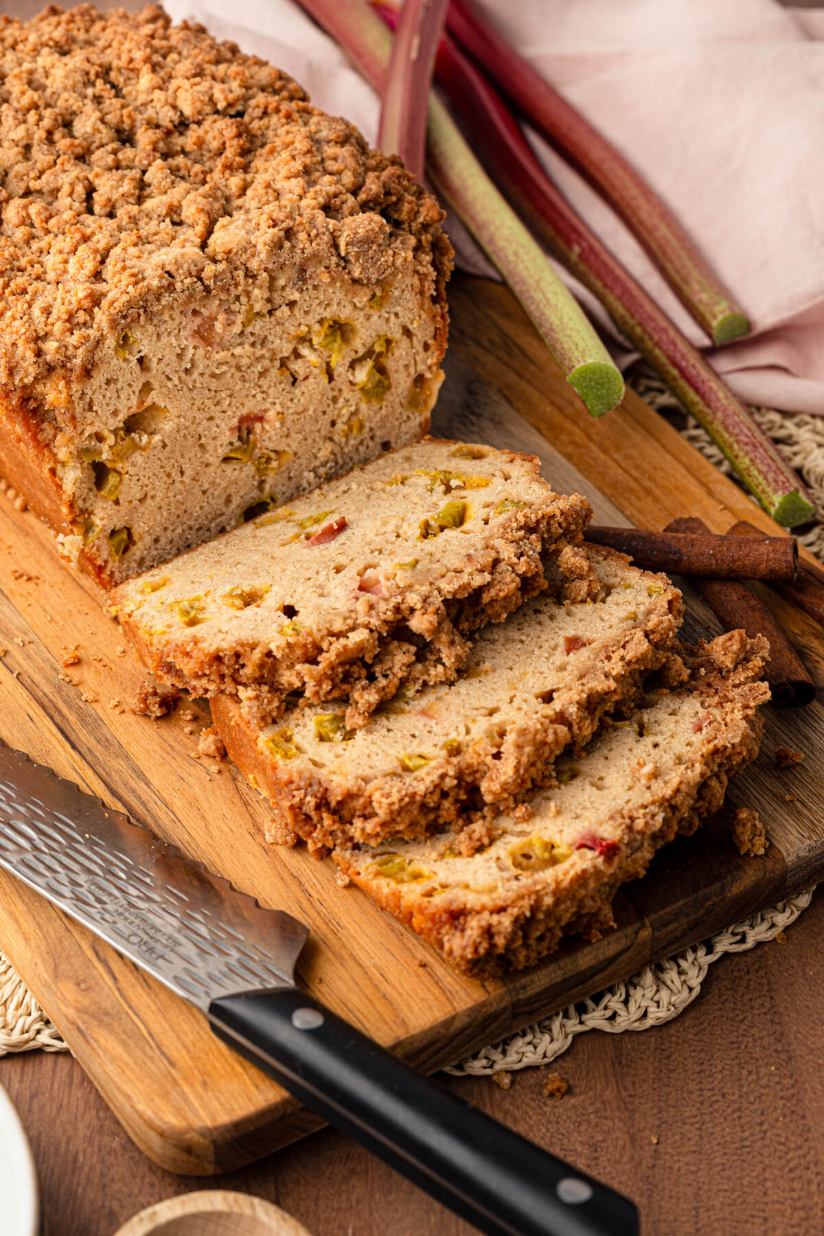 A freshly baked Rhubarb Bread sliced to show the bubbly texture and pieces of cooked rhubarb.