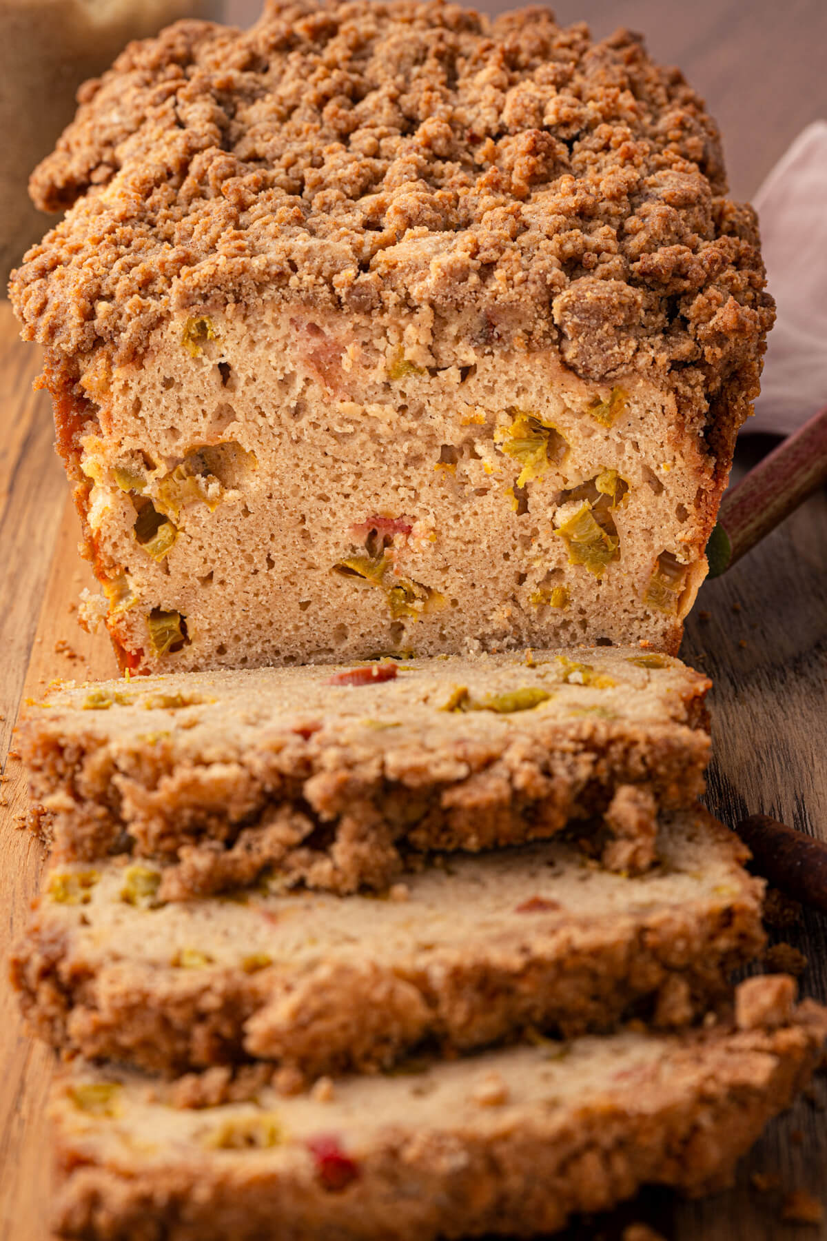 A freshly baked Rhubarb Bread sliced to show the bubbly texture and pieces of cooked rhubarb.