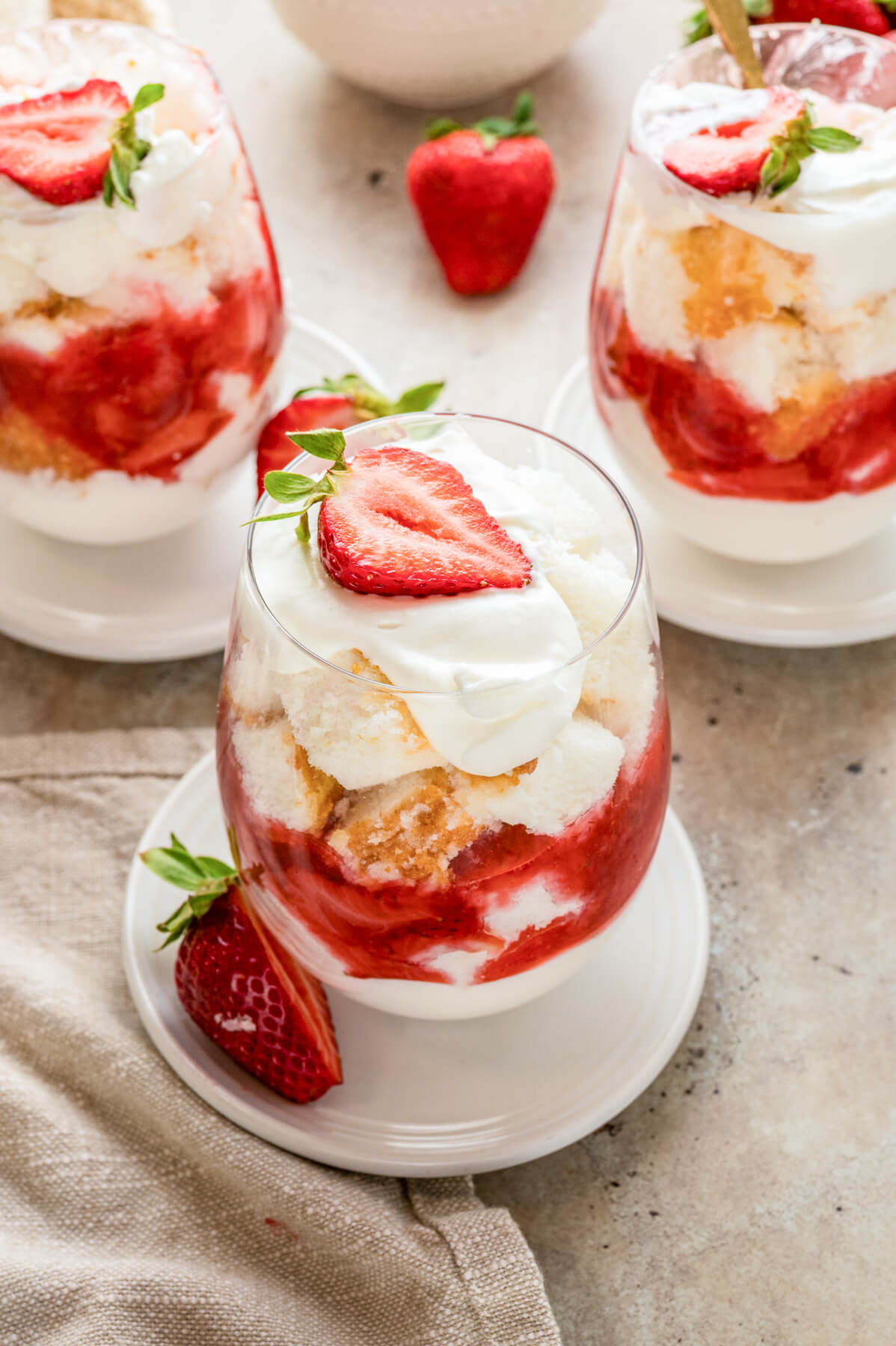 A mini strawberry trifle in a stemless wine glass.