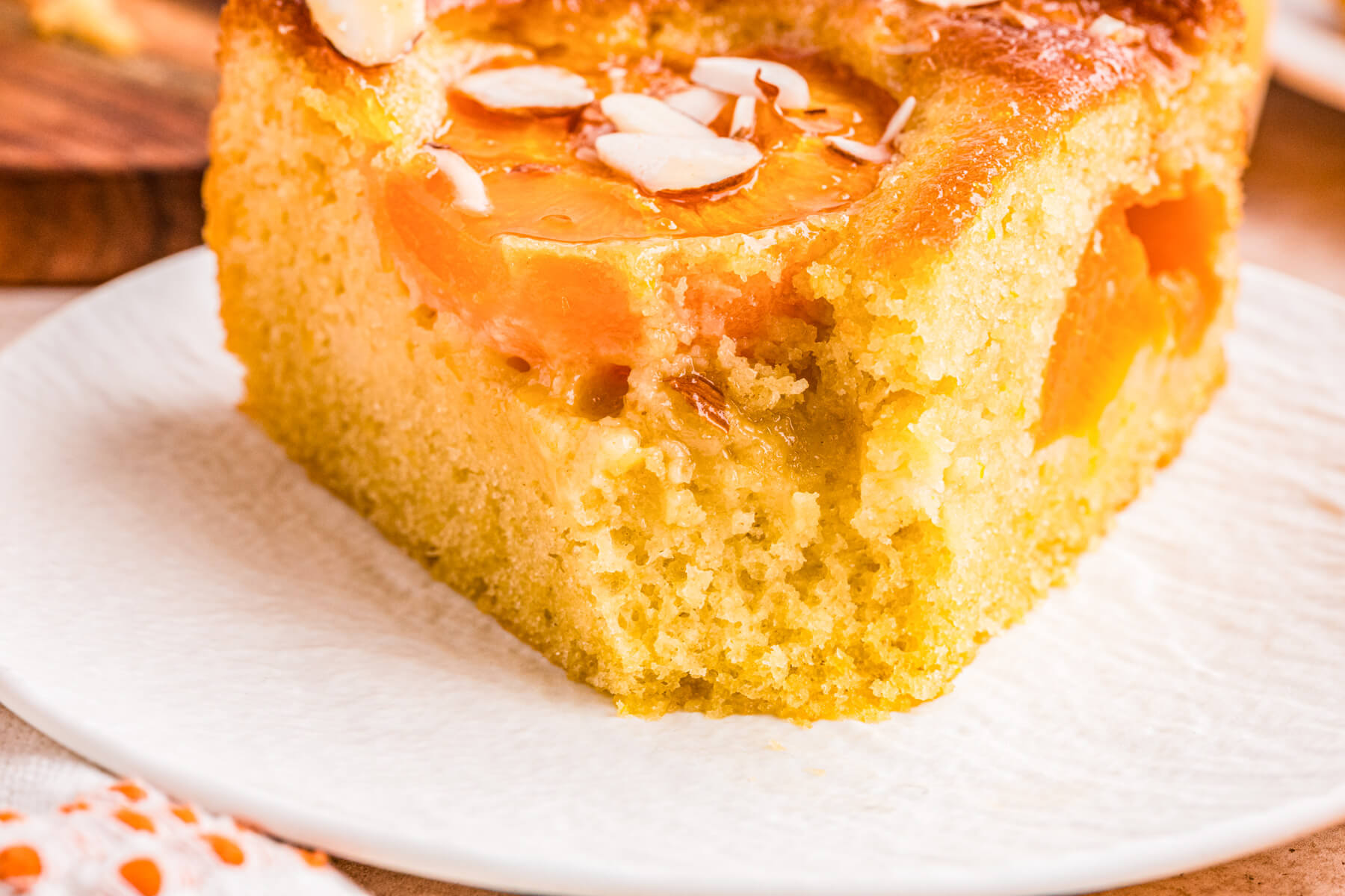 A slice of almond apricot cake with a bite missing.