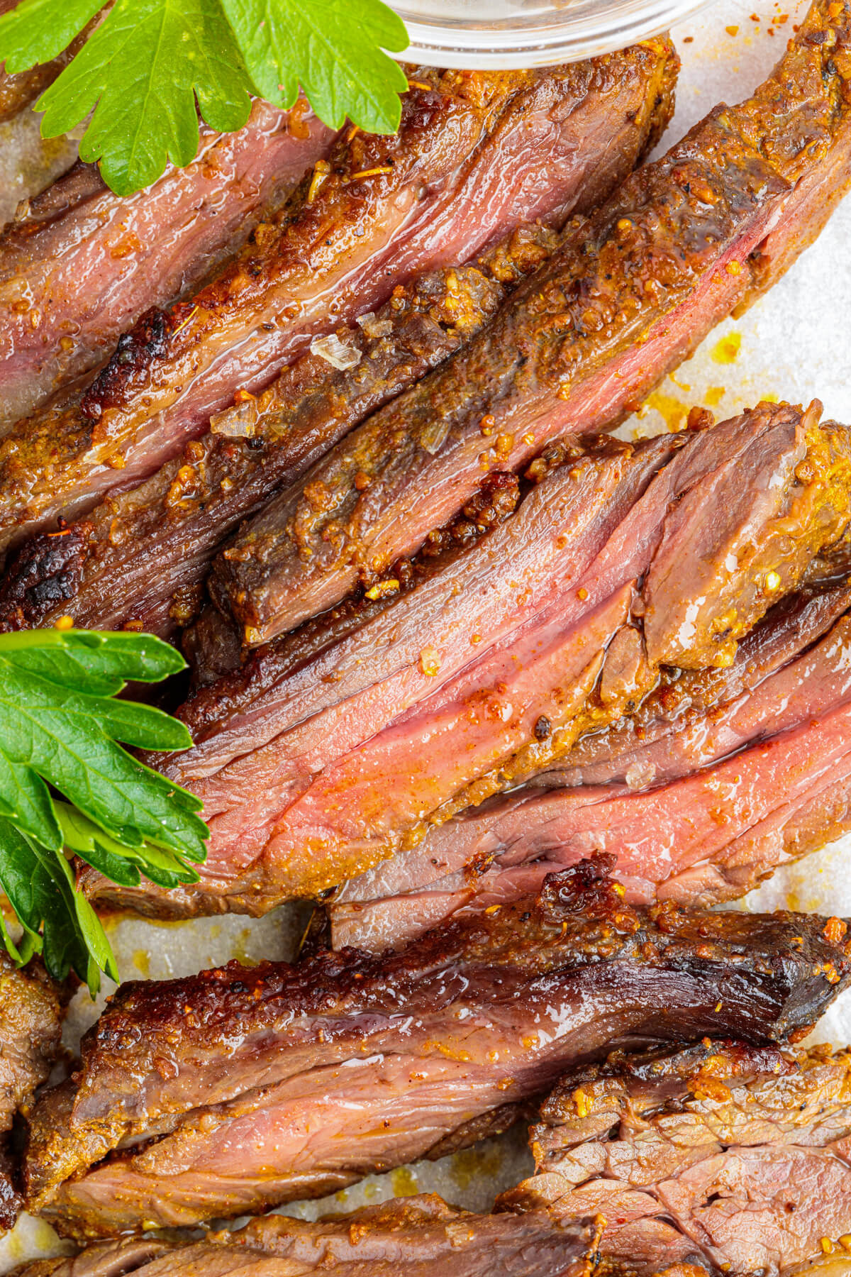 Slices of juicy looking marinated and broiled beef shawarma on a plate.