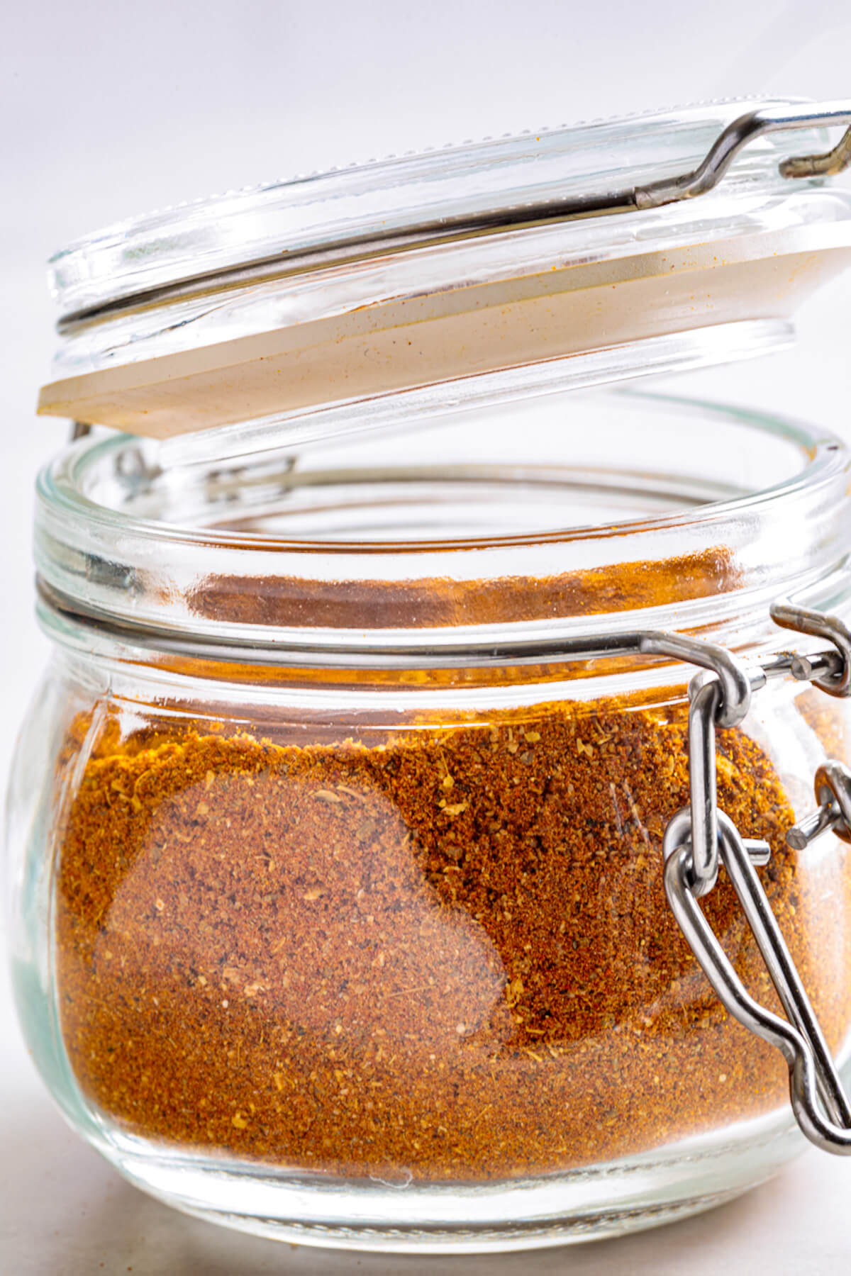 An open jar of vibrant yellow shawarma spice blend.