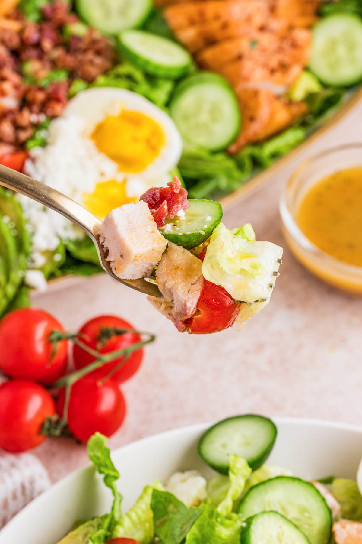 A fork containing a bite sized portion of Chicken Cobb Salad.