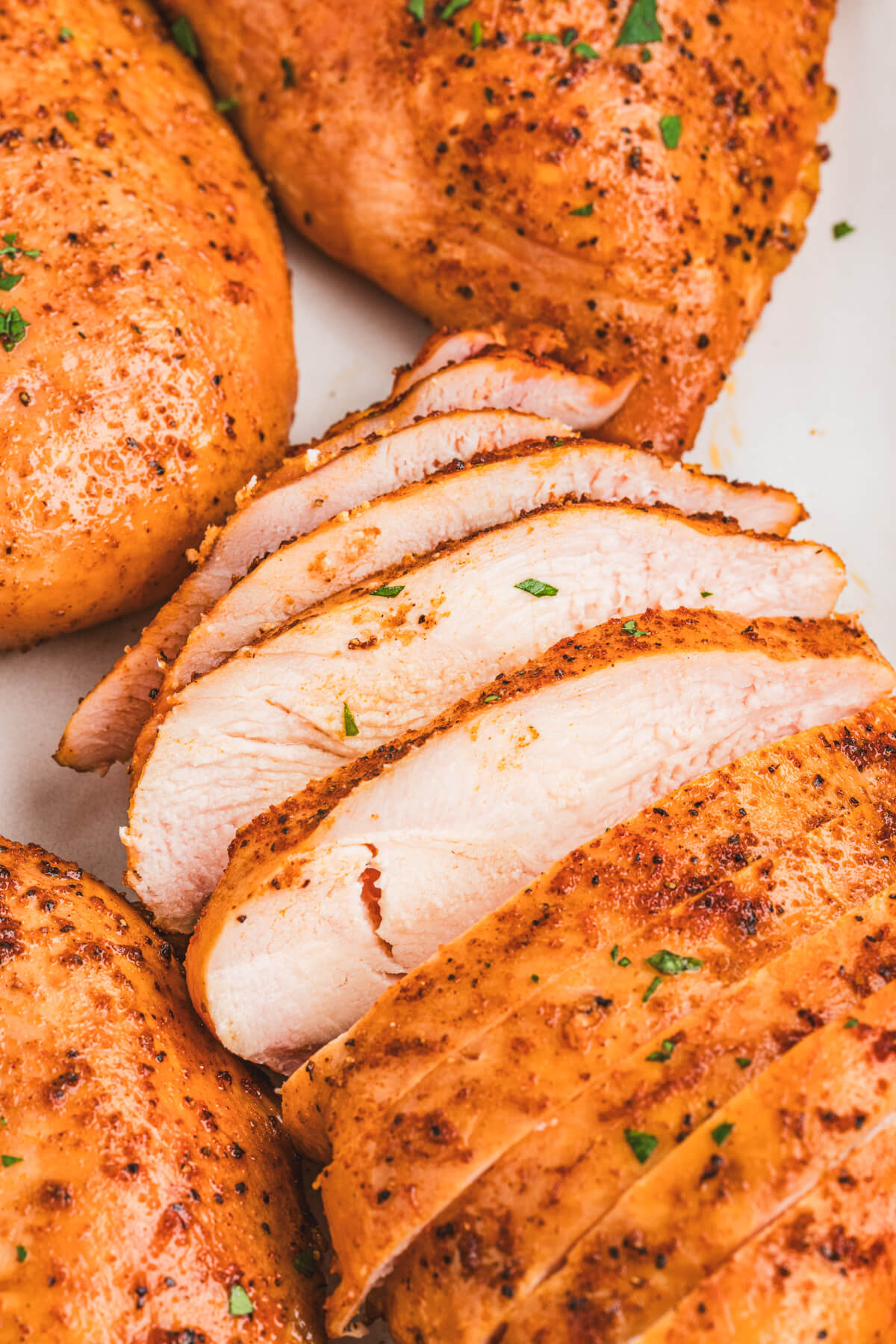 Sliced smoked chicken breasts on a platter.