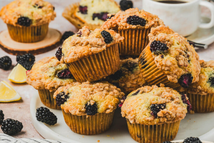 A pile of golden baked blackberry muffins topped with crunchy streusel.