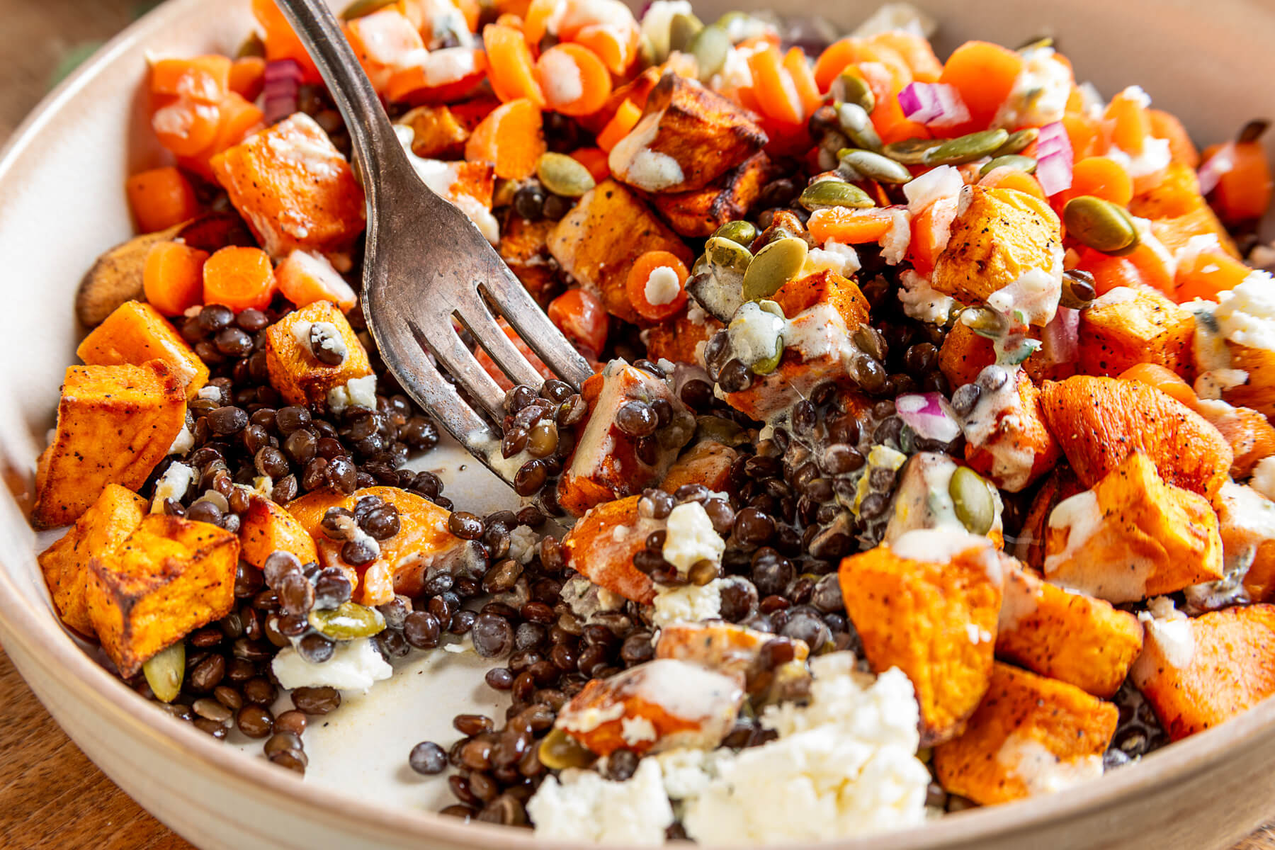 Close up of Sweet Potato Lentil Bowl with bites missing and a fork digging in.